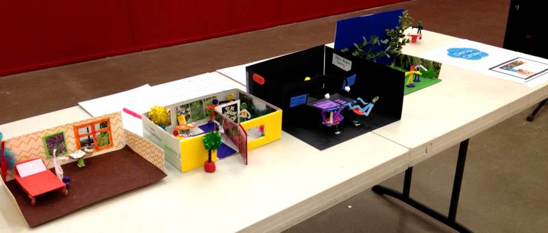 Row of cardboard room settings.